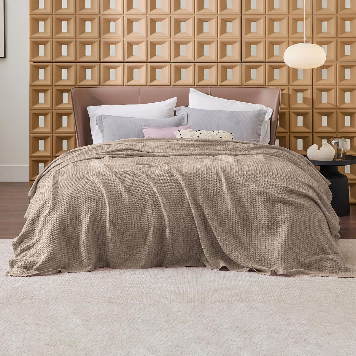 Light beige cotton waffle-weave cooling blanket laid across a bed.