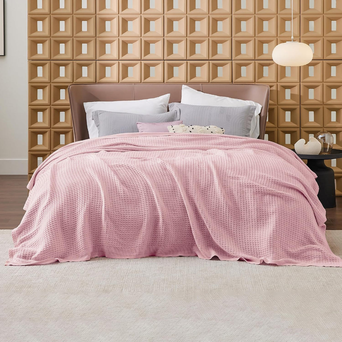 Pink cotton waffle-weave cooling blanket layered over bedding