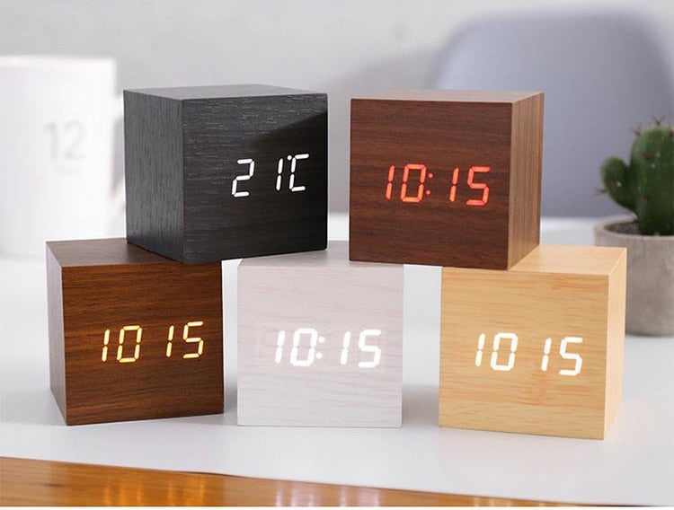 Set of wooden block-style digital clocks with different color displays on a white surface.