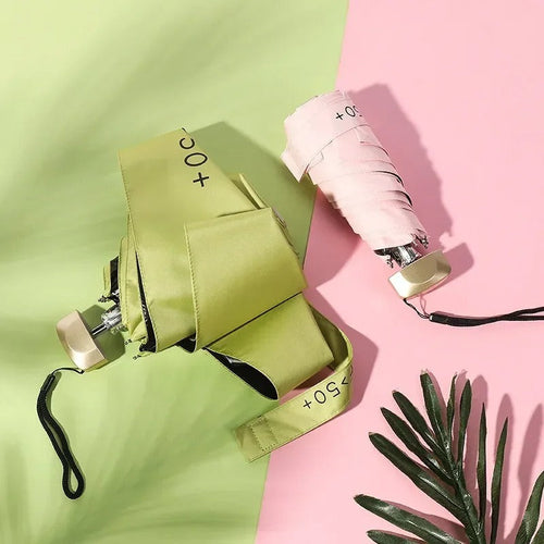 Folded compact mini umbrella in light green with black wrist strap