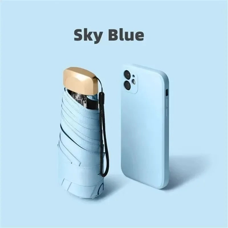 Sky blue compact foldable mini umbrella with wrist strap and gold-toned top