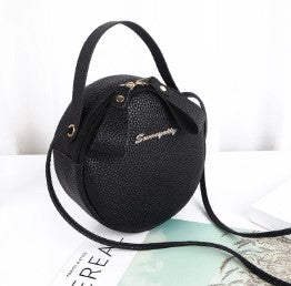 Black round mini crossbody bag with top handle and adjustable shoulder strap