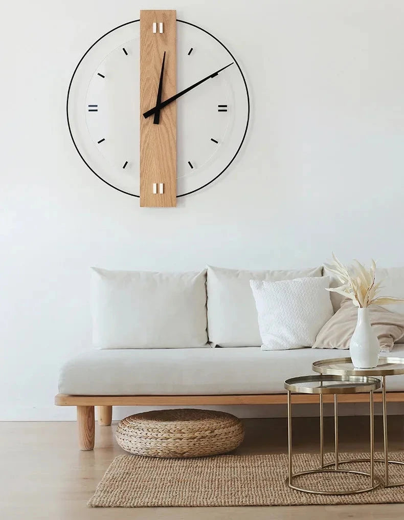 Wooden wall clock on a white wall above a sofa with decorative pillows.