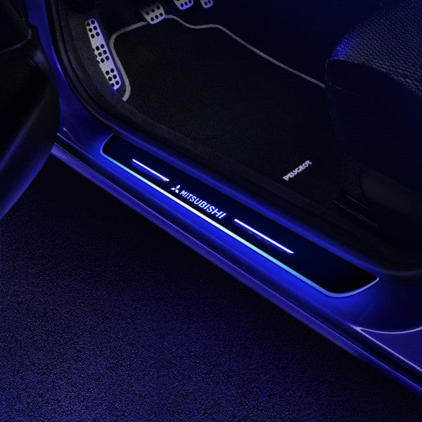Car door interior with illuminated Mitsubishi logo on a dark background