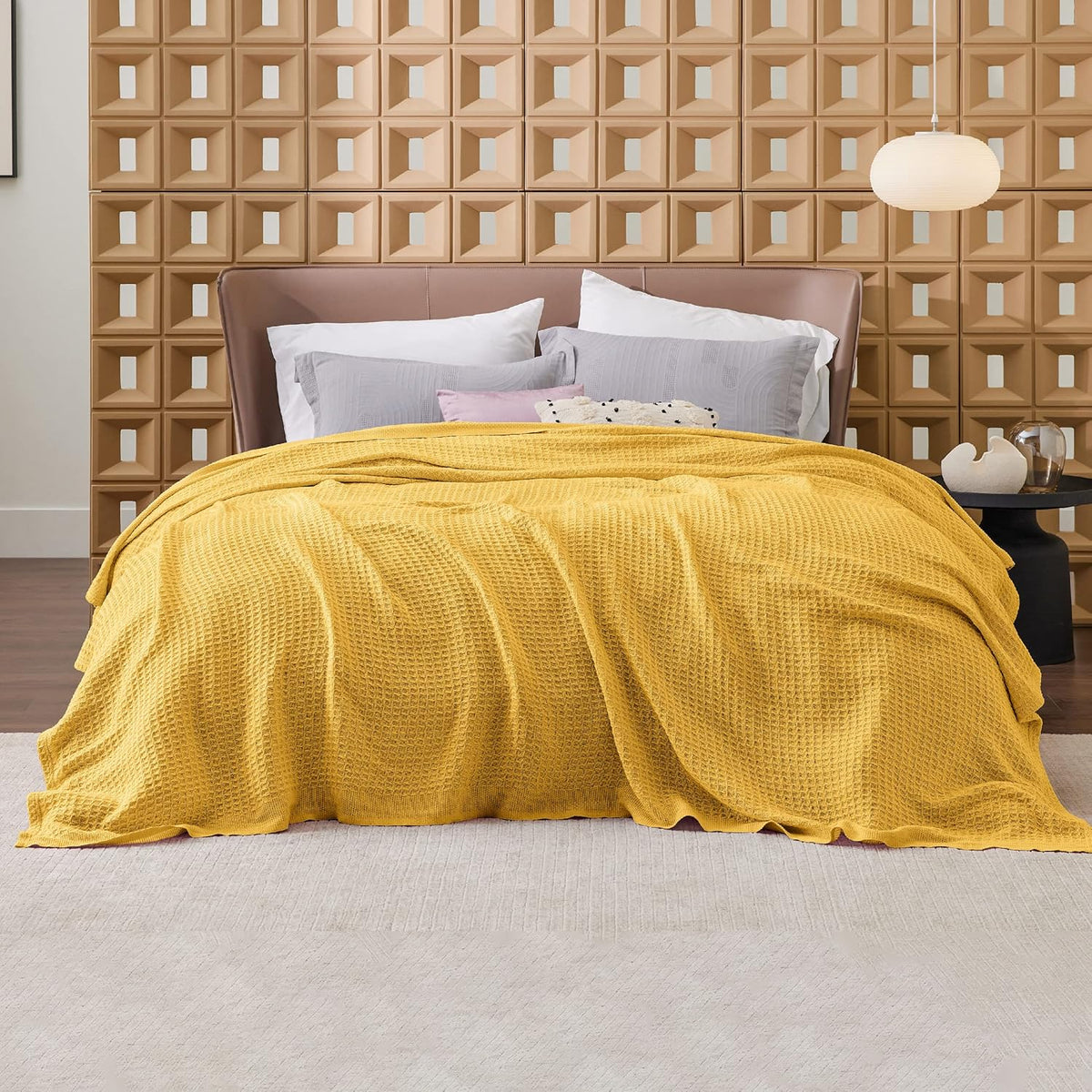 Cotton waffle-weave cooling blanket in mustard-yellow, spread across a bed