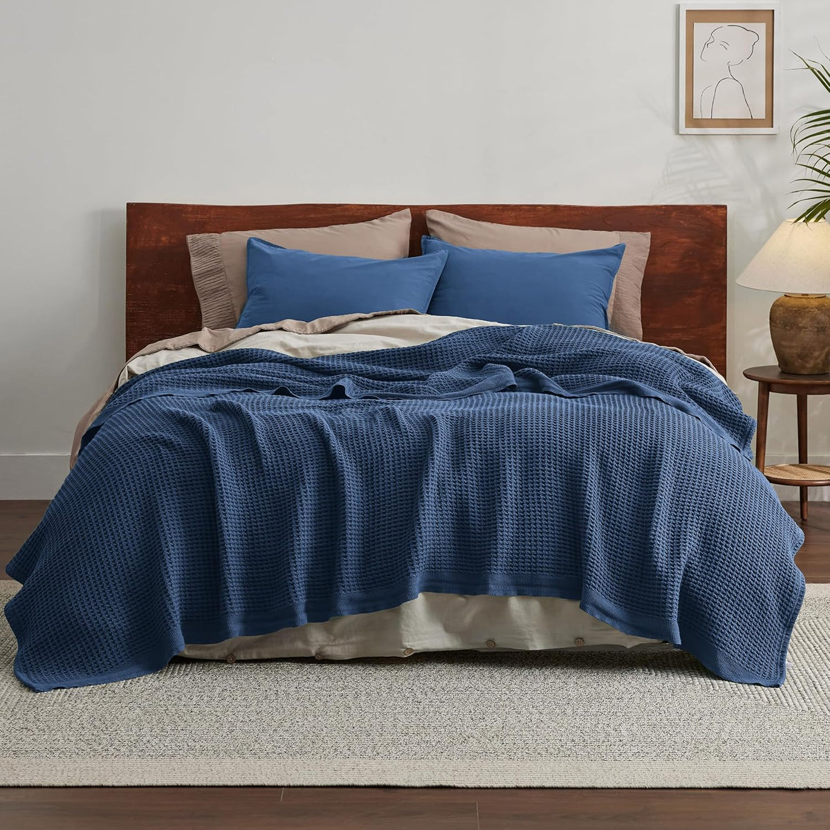 Blue cotton waffle-weave cooling blanket over a bed, covering the mattress top.