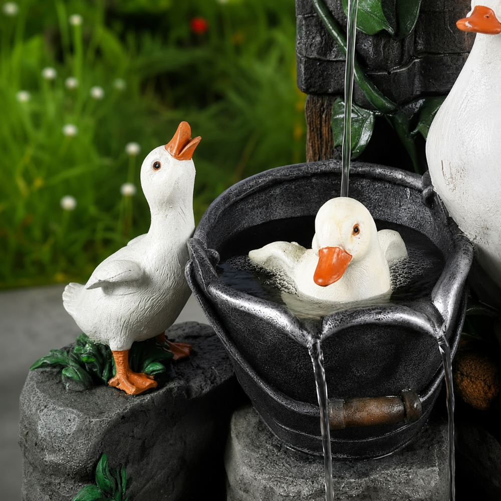 Solar birdbath fountain close-up with white duck and round stone basin, flowing water