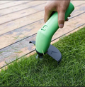 Cordless mini weed trimmer with green body and black cutting head, held above grass