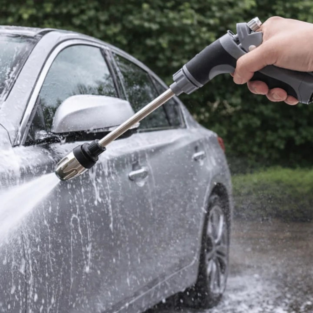 Garden hose pressure nozzle attachment spraying water onto a car with long wand