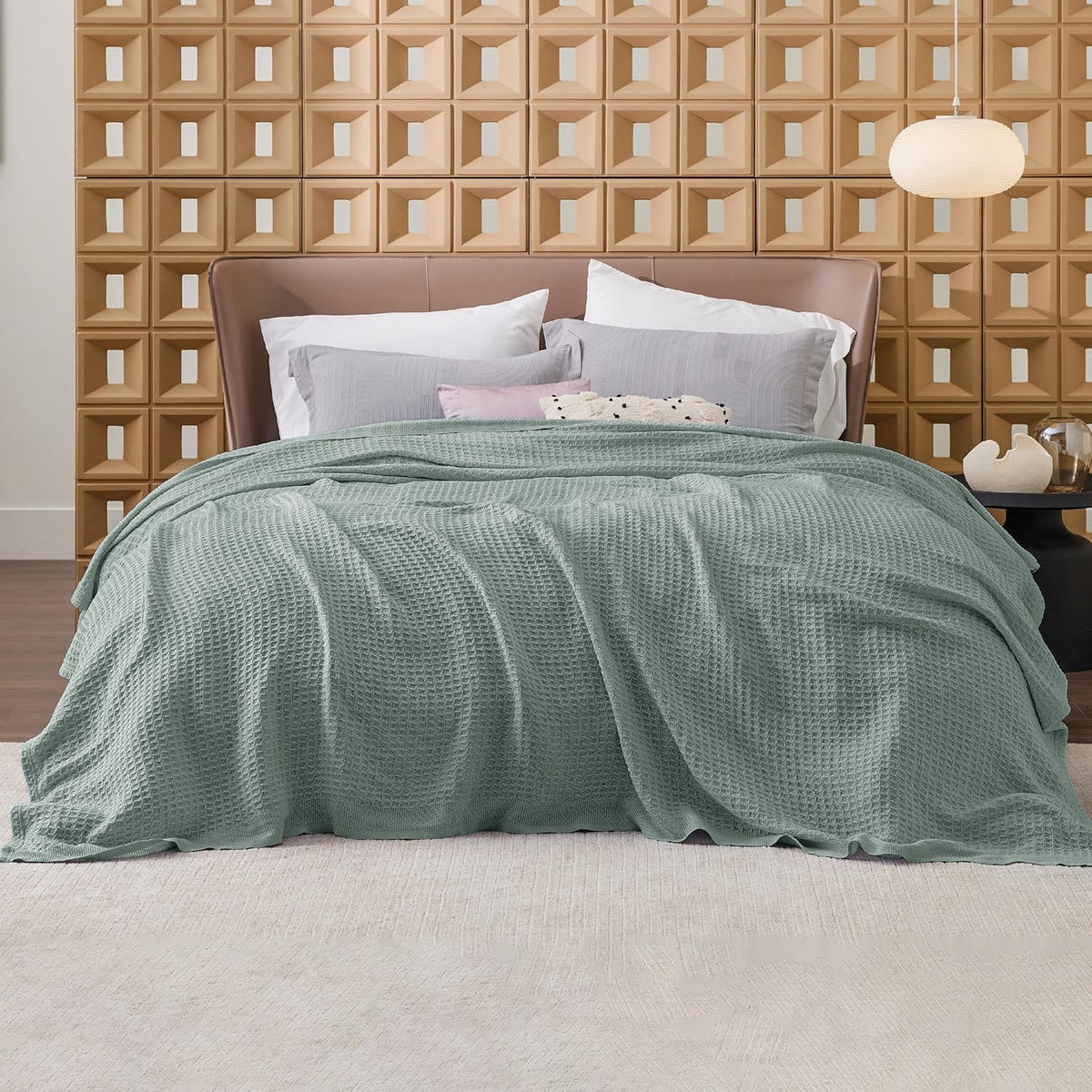 Mint green cotton waffle-weave cooling blanket, spread across a bed for display.