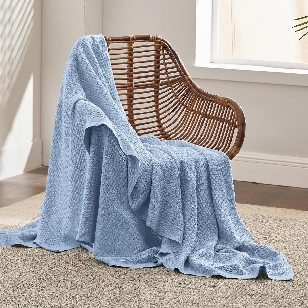 Cotton waffle-weave cooling blanket in light blue, draped over a chair