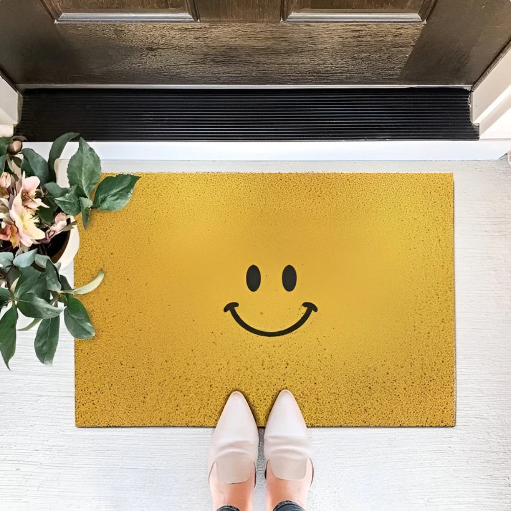 Yellow smiley face entrance doormat with black curved smile and dot eyes
