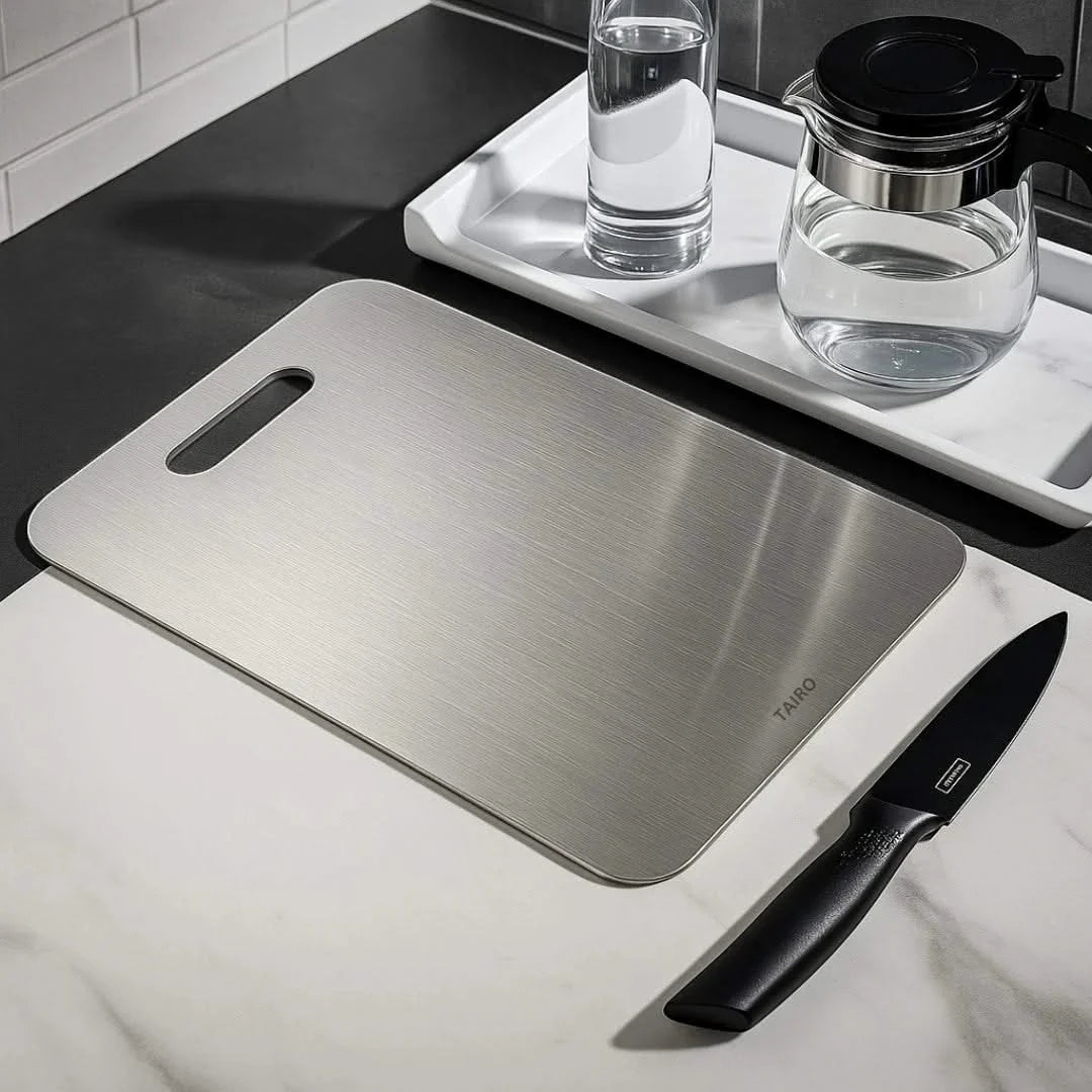 Brushed titanium cutting board on countertop with handle slot
