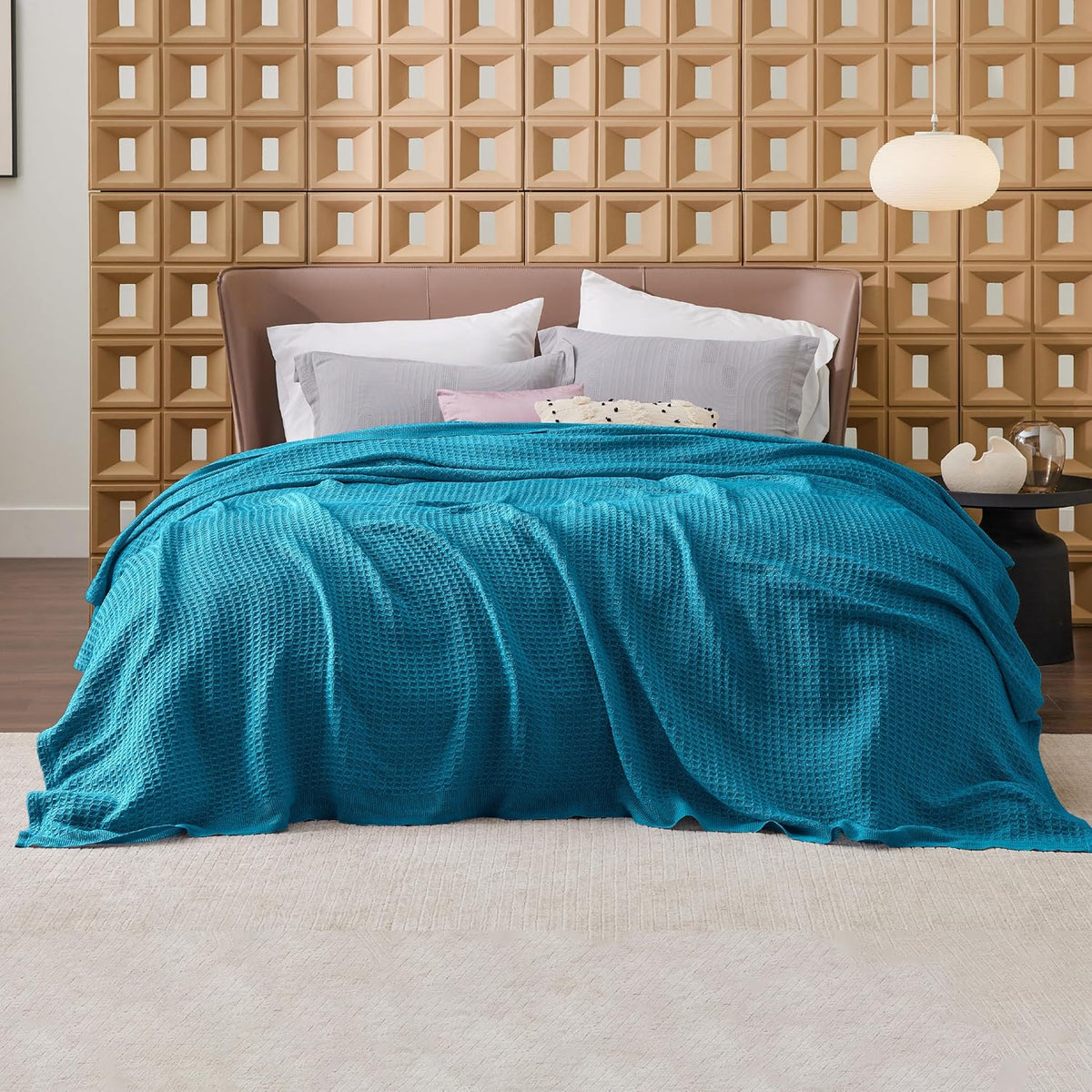 Blue cotton waffle-weave cooling blanket spread over a bed with visible waffle texture.