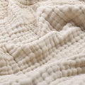 Cotton muslin throw blanket in beige with textured crinkle weave pattern