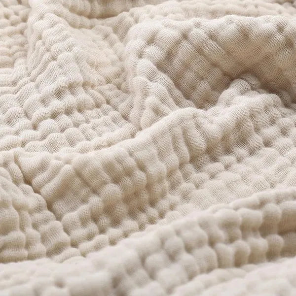 Cotton muslin throw blanket in beige with textured crinkle weave pattern