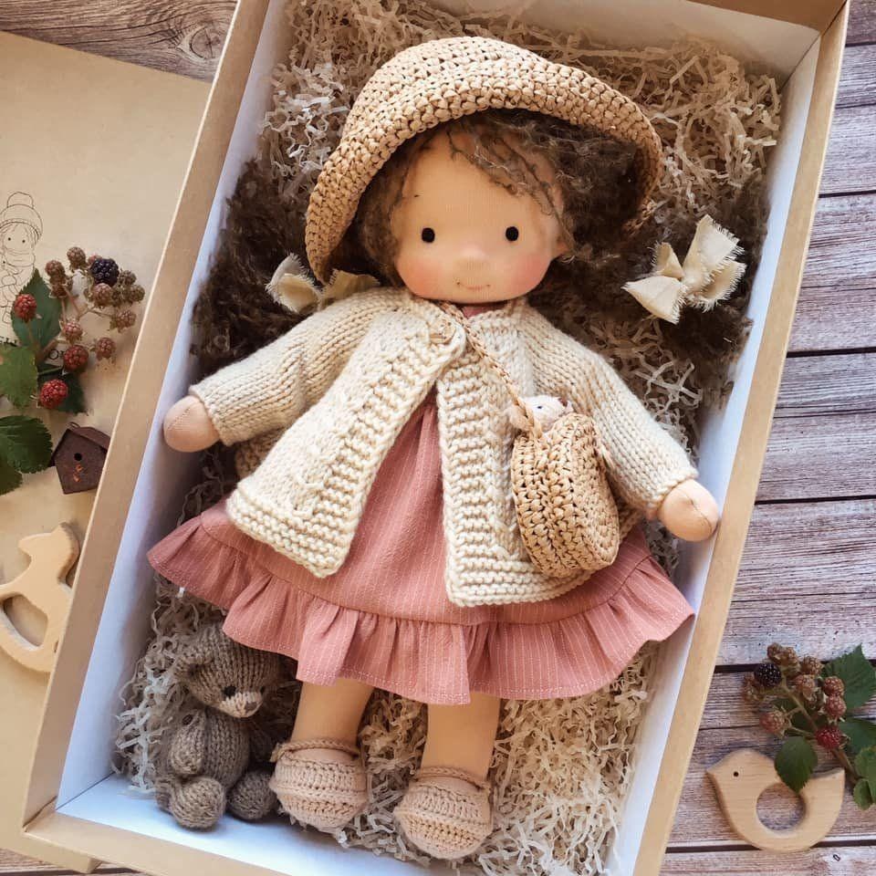 Handmade wool doll toy with cream knit cap, pink skirt and scarf, with teddy bear