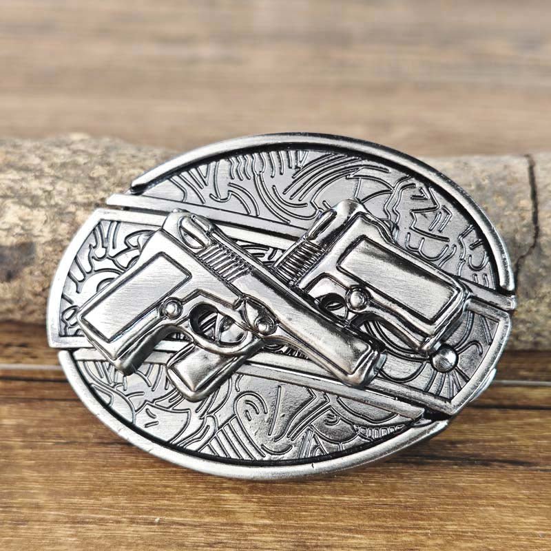 Western oval belt buckle with crossed revolver engravings and ornate border, silver-tone