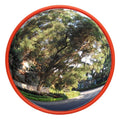Round wide-angle wall mirror with orange frame, reflecting an outdoor street scene