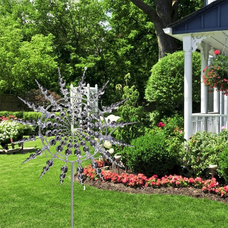 Decorative garden spinner in a lush garden with flowers and a house in the background