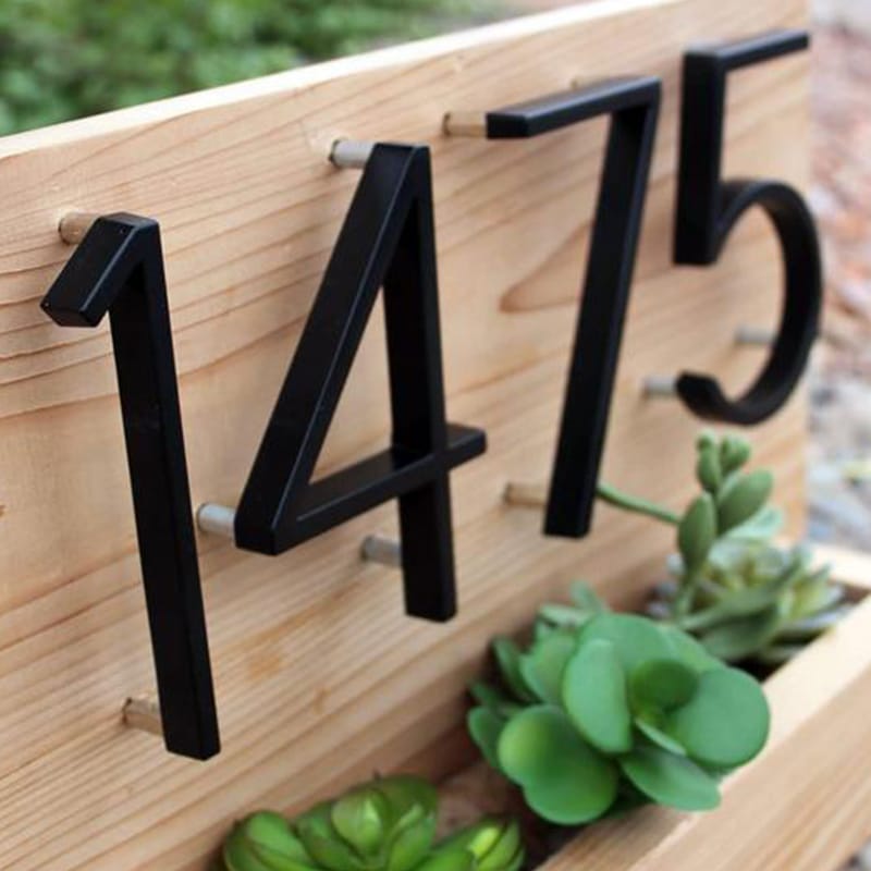 Black metal house numerals, large raised digits, close-up